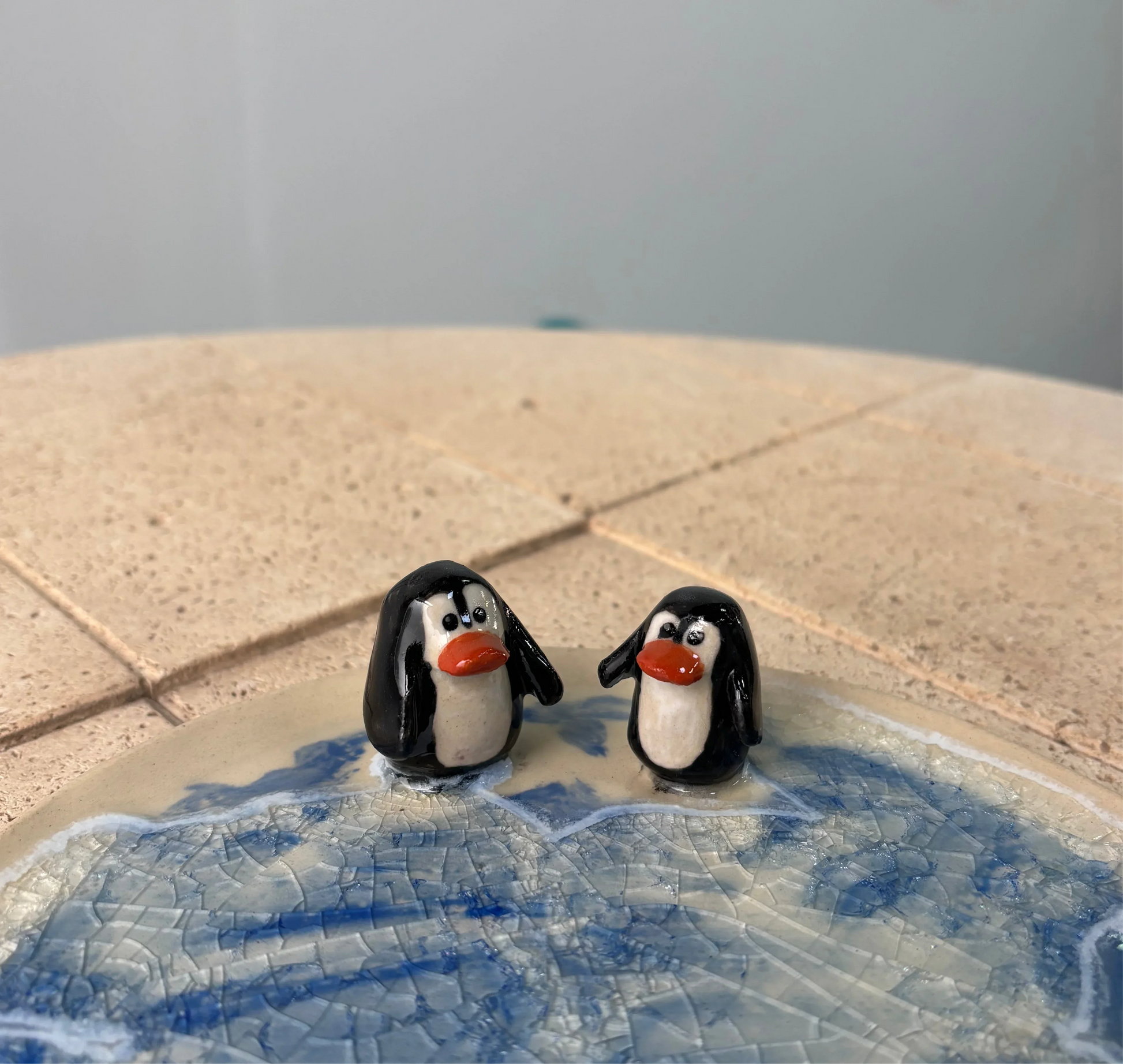 Plato azul con figuras de pingüinos de cerámica artesanal pintadas a mano, diseño por Hecho por Su.