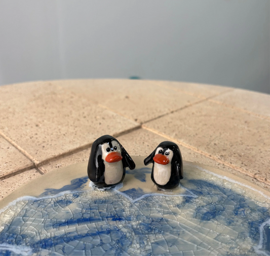 Plato azul con figuras de pingüinos de cerámica artesanal pintadas a mano, diseño por Hecho por Su.